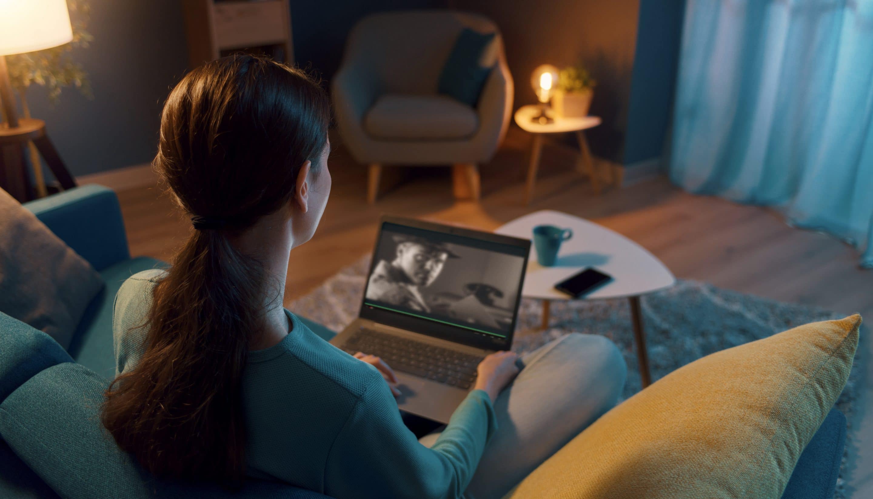 Woman resting on the sofa and connecting with her laptop